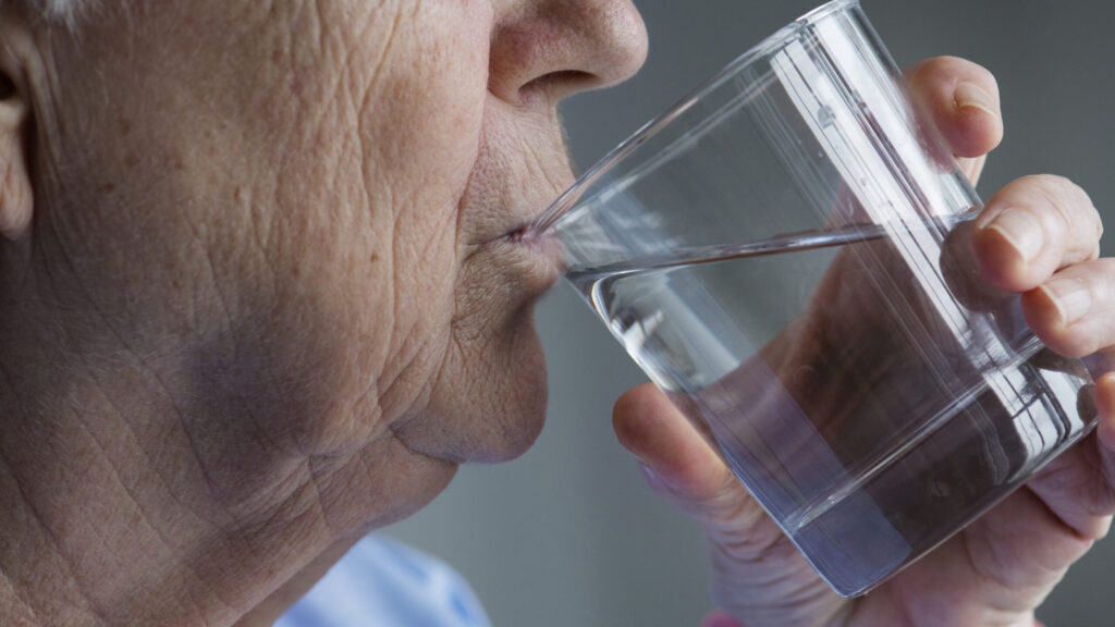 Side View Of Elderly Woman Drinking Water